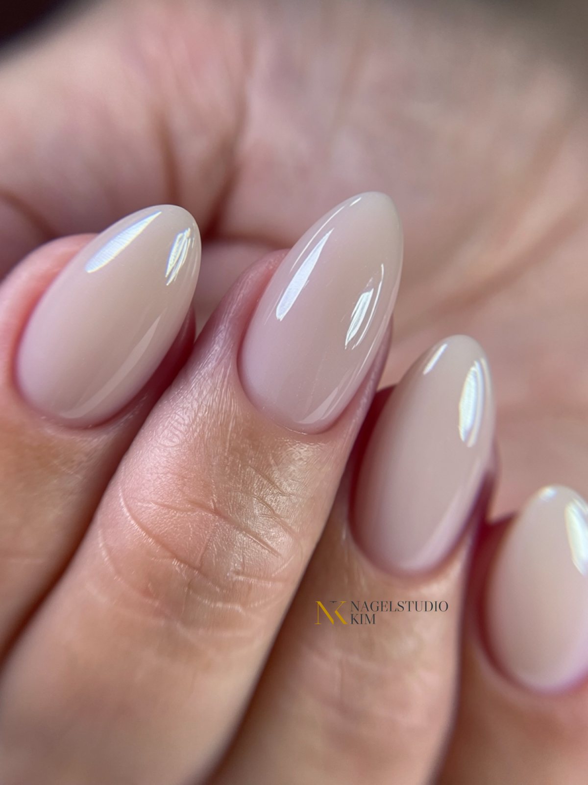 Glanzende nude nagels in amandelvorm